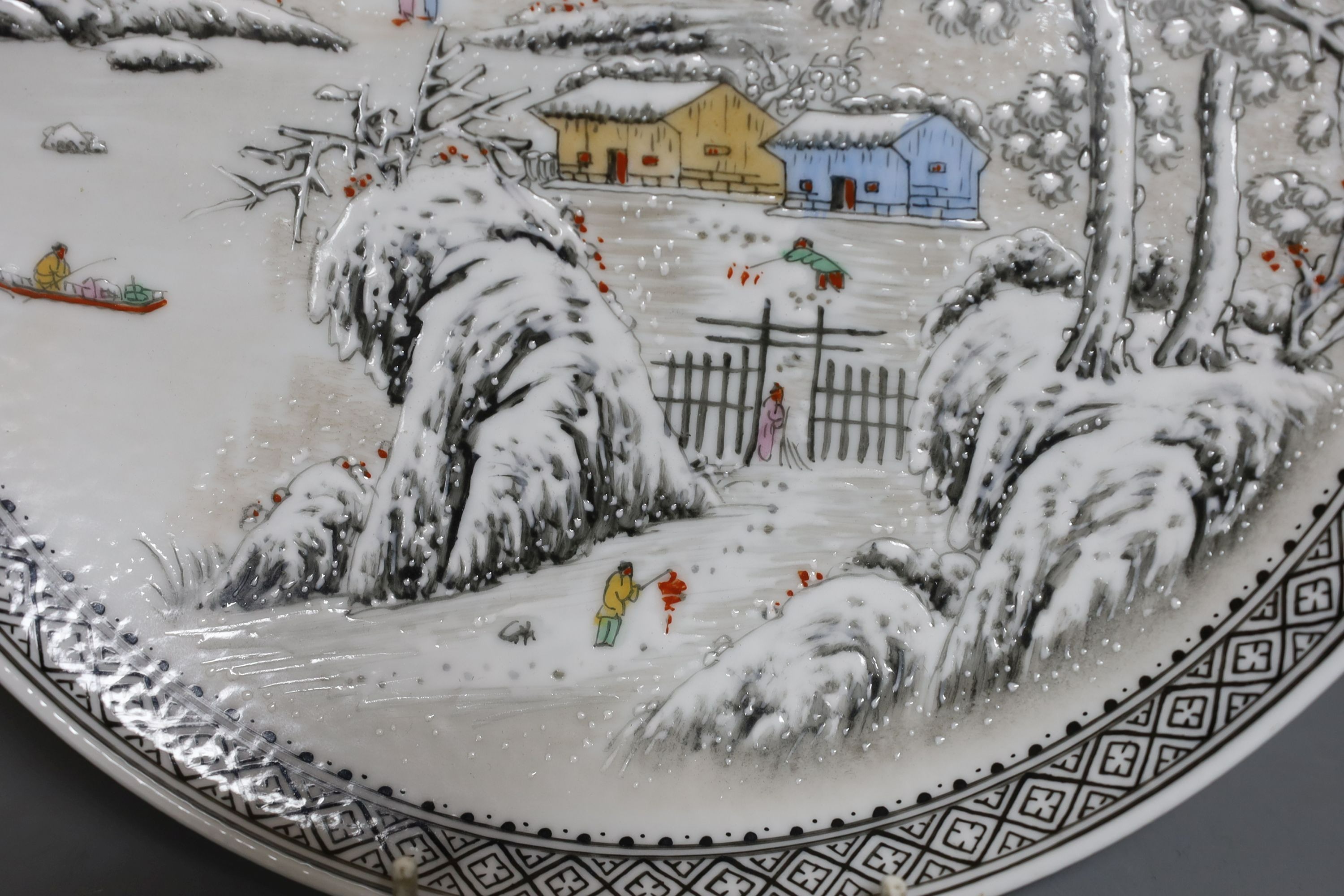 A Chinese famille rose plate depicting a winter scene - 27cm diameter